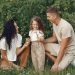 A joyful family enjoying time together in a lush green field.